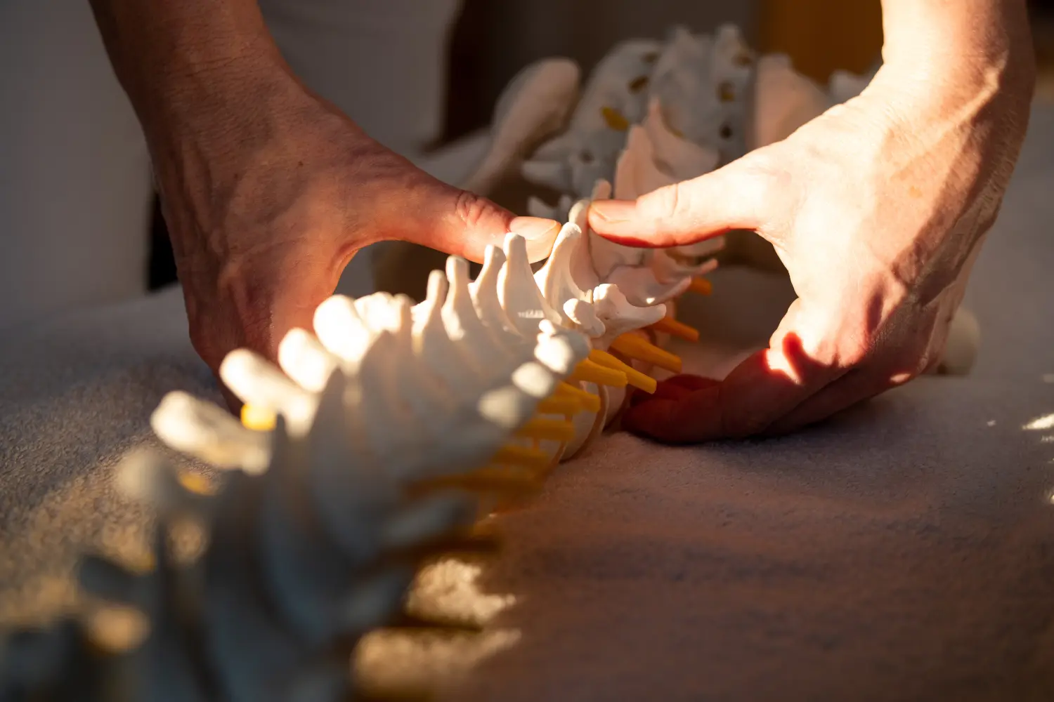 Therapeuten Hände an Wirbelsäule mit Lichteinfall